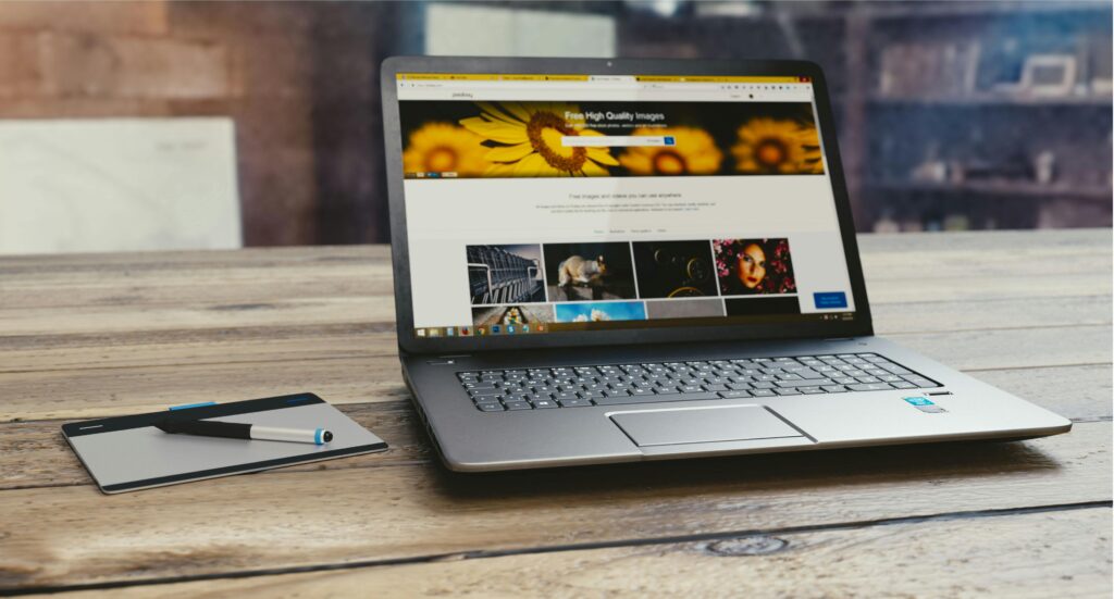 pexels-photo-109371-109371 Laptop with open webpage on wooden desk, accompanied by tablet and pen, representing digital work setup.